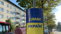 Tienvarsipylvääseen on kiinnitetty sinikeltainen kyltti, jossa on Slava Ukraini -teksti.