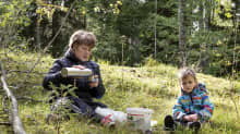 Marjaana Backman ja Arvi Henriksson kahvittelevat metsässä.