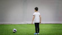 lapsi pelaamassa jalkapalloa