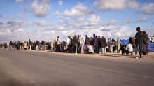 Pitkä jono libyalaisia pakolaisia maantiellä