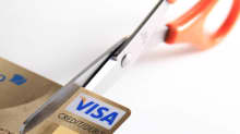 Kuvassa sakset leikkaavat luottokortin kulmaa. 