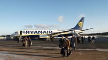 Matkustajia ja Ryanairin kone Tampere-Pirkkalan lentokentällä.