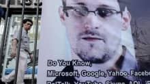 Ohikulkija käveli Edward Snowdenia tukevan bannerin ohi Hongkongissa 18. kesäkuuta.