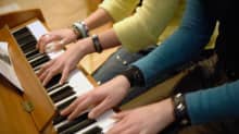 Musiikkiluokkalaiset tuntevat suurempaa yhteenkuuluvuutta kuin tavallisessa koululuokassa opiskelevat. Kaksi tyttöä soittavat yhdessä pianoa. 