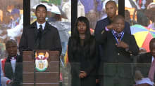 Nelson Mandelan muistojuhlassa puhujalavalla esiintynyt huijariksi paljastunut viittomakielen tulkki oikealla.
