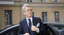 Björn Wahlroos astumassa ulos kadulle tummasta henkilöautosta.
