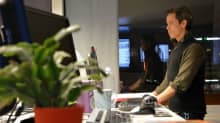 Mies työskentelee tietokoneella seisoma-asennossa.