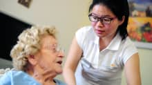 Kiinalainen hoitaja hoitaa vanhusta hoitokodissa Frankfurtissa