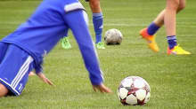 Nuoret pelaajat harjoittelevat jalkapalloa.