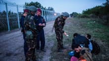Viranomaiset tarkistavat rajalla pidätettyjen dokumentteja Röszkessa Serbian ja Unkarin välisellä rajalla 15. syyskuuta 2015. 