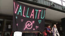 Vallattu-banneri roikkuu Helsingin yliopiston Porthania-rakennuksen edessä.