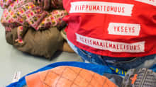 Vapaaehtoinen ja lapsi Suonenjoen hätämajoituskeskuksessa.