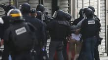 Poliisit pidättävät henkilön Saint Denisin tapahtumista.
