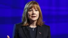 Mary Barra puhujalavalla kädet levitettyinä