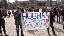 ihmisiä banderollin kanssa torilla