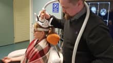 Dr. Aleksi Sihvonen stimulates researcher Sini Hämeläinen's brain magnetically.