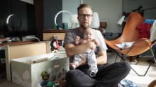 Mies pitää lasta sylissään.