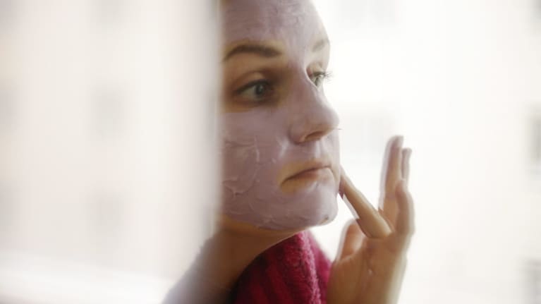 Nainen kasvonaamio kasvoillaan.