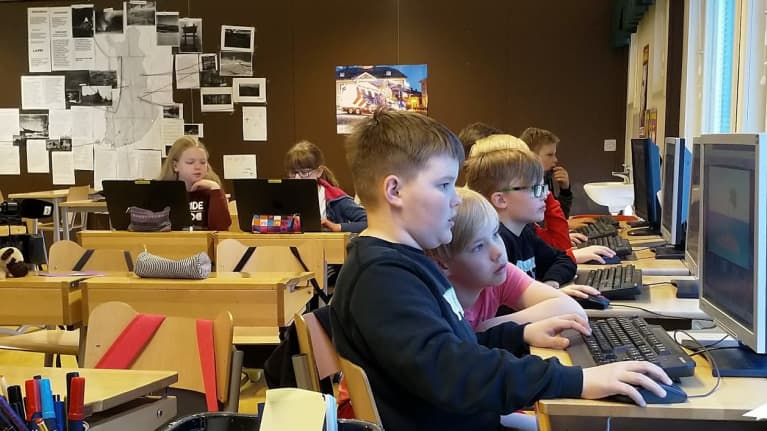 Pojat ja tytöt tietokoneiden ääressä