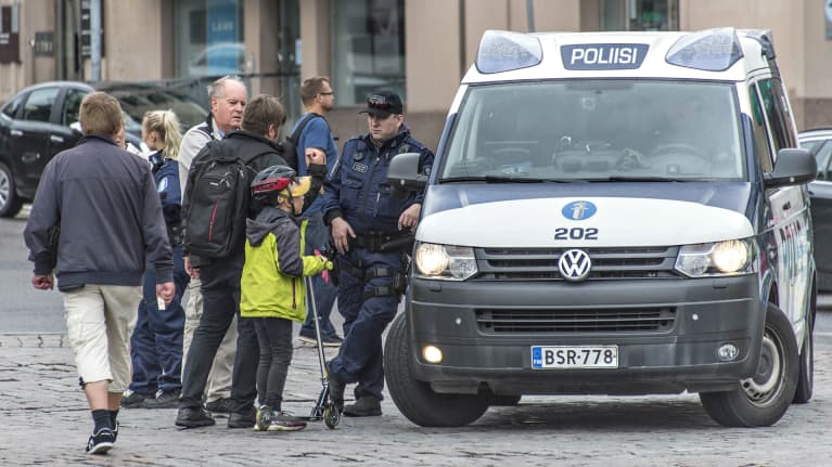 Poliisi kohta kansalaisia Turun torilla.