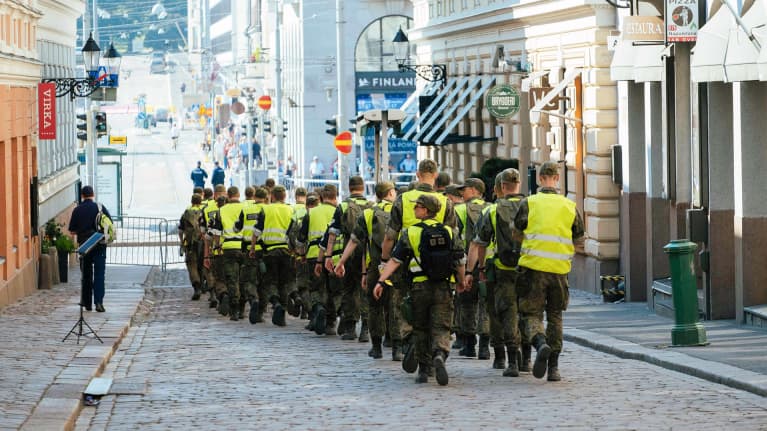Sotilaspoliisit kävelevät presidentinlinnan läheisyydessä Helsingissä.