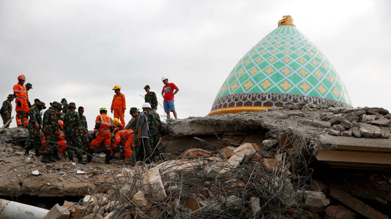 Avustustyöntekijöitä romahtaneen moskeijan raunioilla Lombokilla.