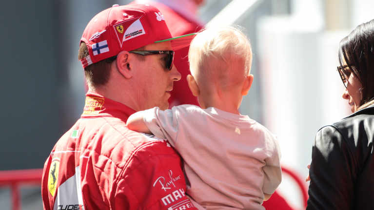 Kimi Räikkönen sylissään poikansa Robin ja vierellään vaimonsa Minttu.