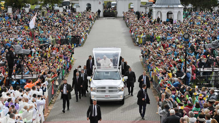 Paavi avoautossa väkijoukon keskellä.