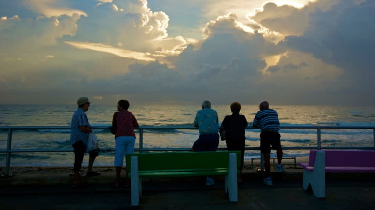 Ihmiset katsovat auringonlaskua.