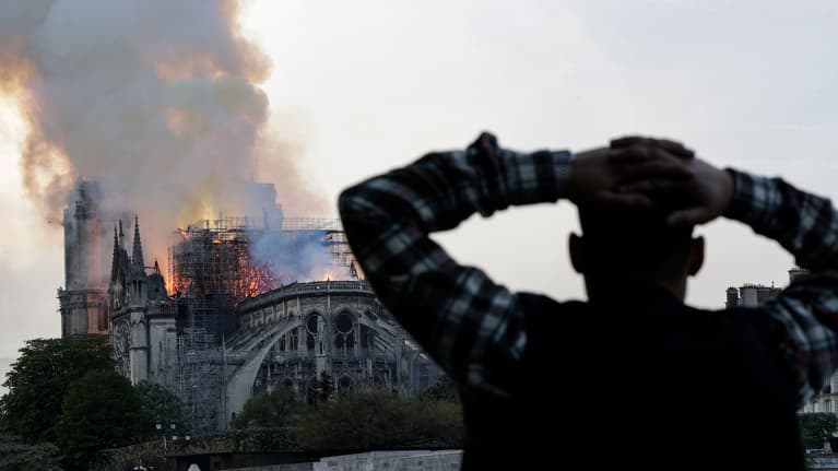 Mies katselee palavaa Notre Damen katedraalia.