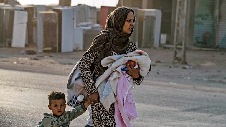 Äiti pakeni lastensa kanssa Turkin ilmaiskuja Ras al-Ainin kaupungissa Turkin ja Syyrian rajalla keskiviikkona.