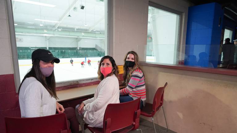 Brandi Rucinski, Angie Forsythe ja Nikki Sesko katselevat kahvion ikkunasta jääkiekko-ottelua.