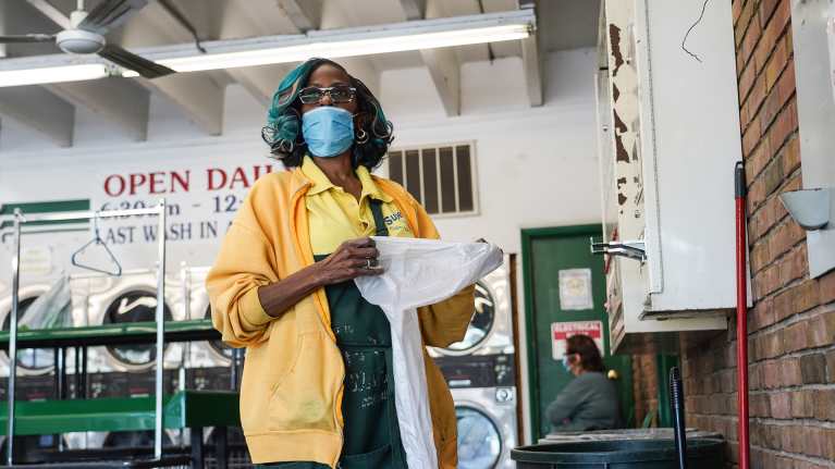 Pesulan johtaja Cathy Ewing kasvomaskissa pesulassaan.