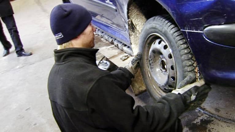 Auton renkaita vaihdetaan korjaamossa.