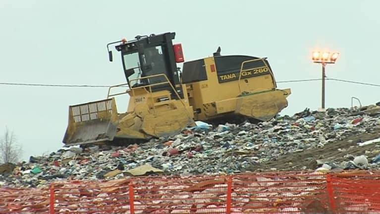 Työkone jäteksan päällä. 