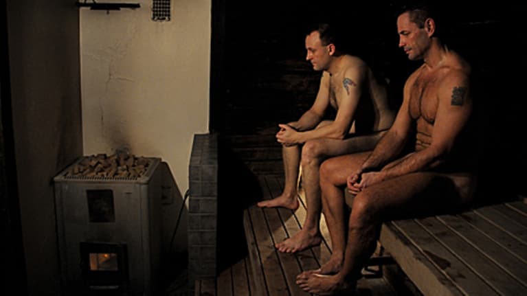 Kaksi miestä saunan lauteilla.