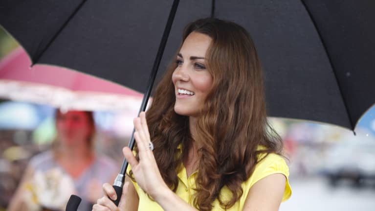 Herttuatar Catherine vilkuttaa sateenvarjon alta.