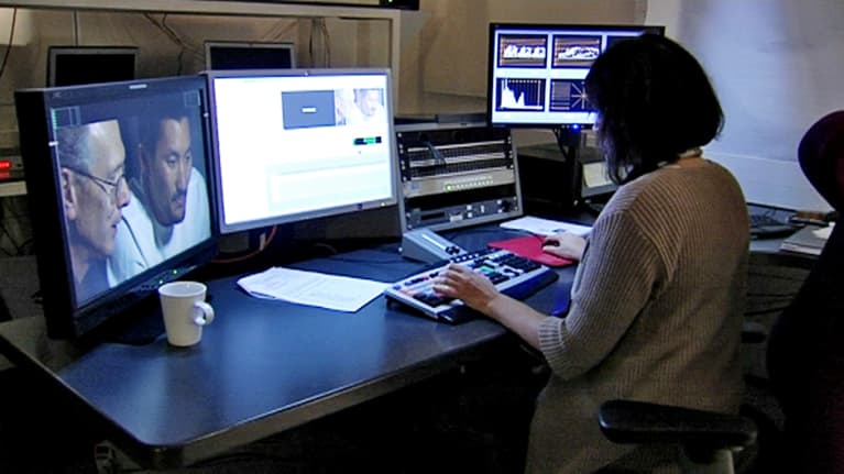 Elokuvien ja tv-ohjelmien kääntäminen on myös hyvin tietoteknistä puuhaa. Kääntäjä istuu työpisteessään neljän eri monitorin edessä.