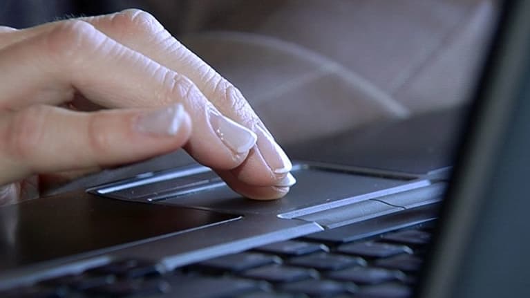 Henkilö käyttämässä kannettavaa tietokonetta.