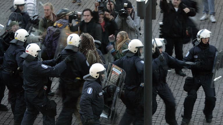 Poliiseja ja mielenosoittajia Smash Asem -mielenosoituksen aikana Kiasman edustalla Helsingissä.