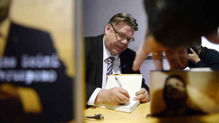 Timo Soini signeeraa kirjaansa.