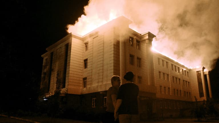 Ukrainalaisnaiset seisoivat pommituksen kohteena olleen palavan koulun edustalla Donetskissa 27. elokuuta 2014. 