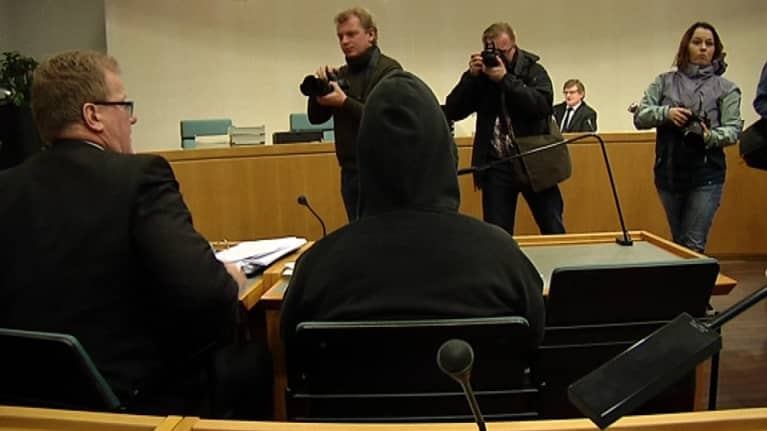 Kuvaajat ottavat valokuvia kirjastopuukotuksesta syytetystä.