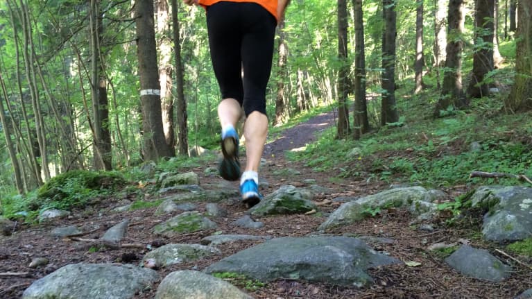 Juoksevat jalat metsäympäristössä.