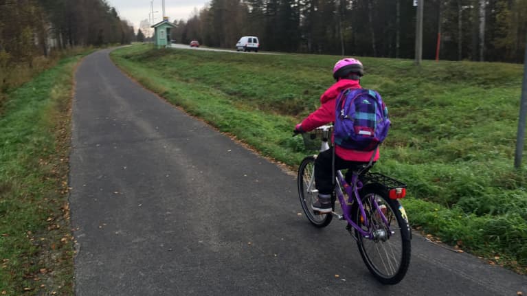 Lapsi pyöräilee kouluun.