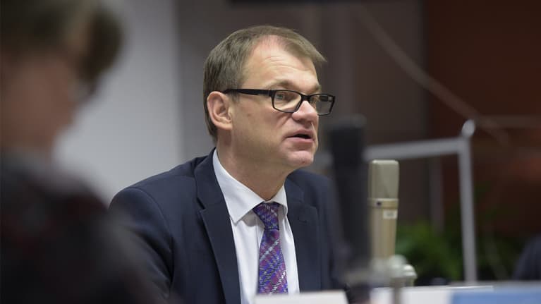 Pääministeri Juha Sipilä mikrofonin takana.