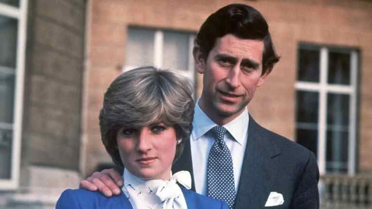 Diana ja Charles seisovat rinnakkain. Charlesin käsi on Dianan hartialla.