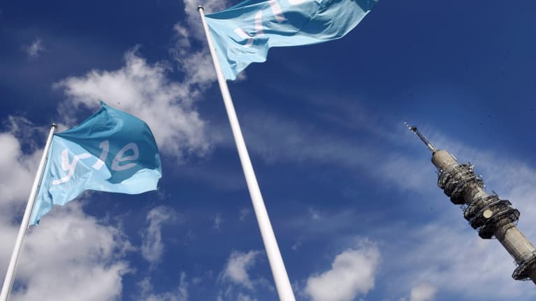 Yleisradion linkkitorni ja lippuja mediatalon edustalla. 