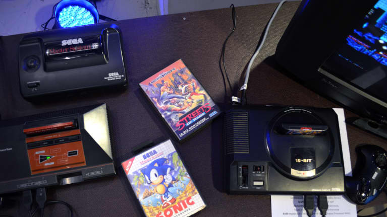 Retrokonsoleita ja pelejä pöydällä