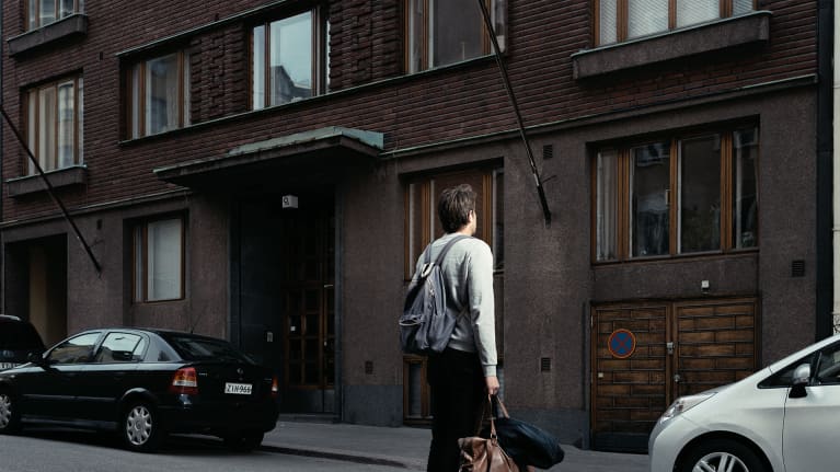 Magnus Bratten seisoo kerrostalon edessä.